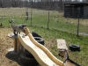 Mama waits at the bottom of the slide for her daughter